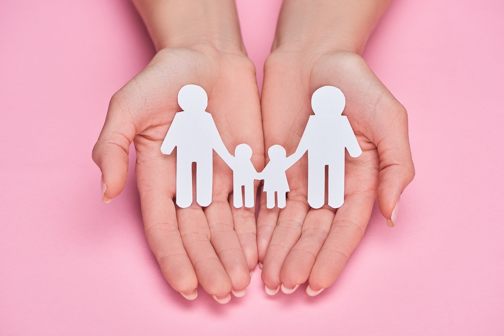 Hands holding paper family