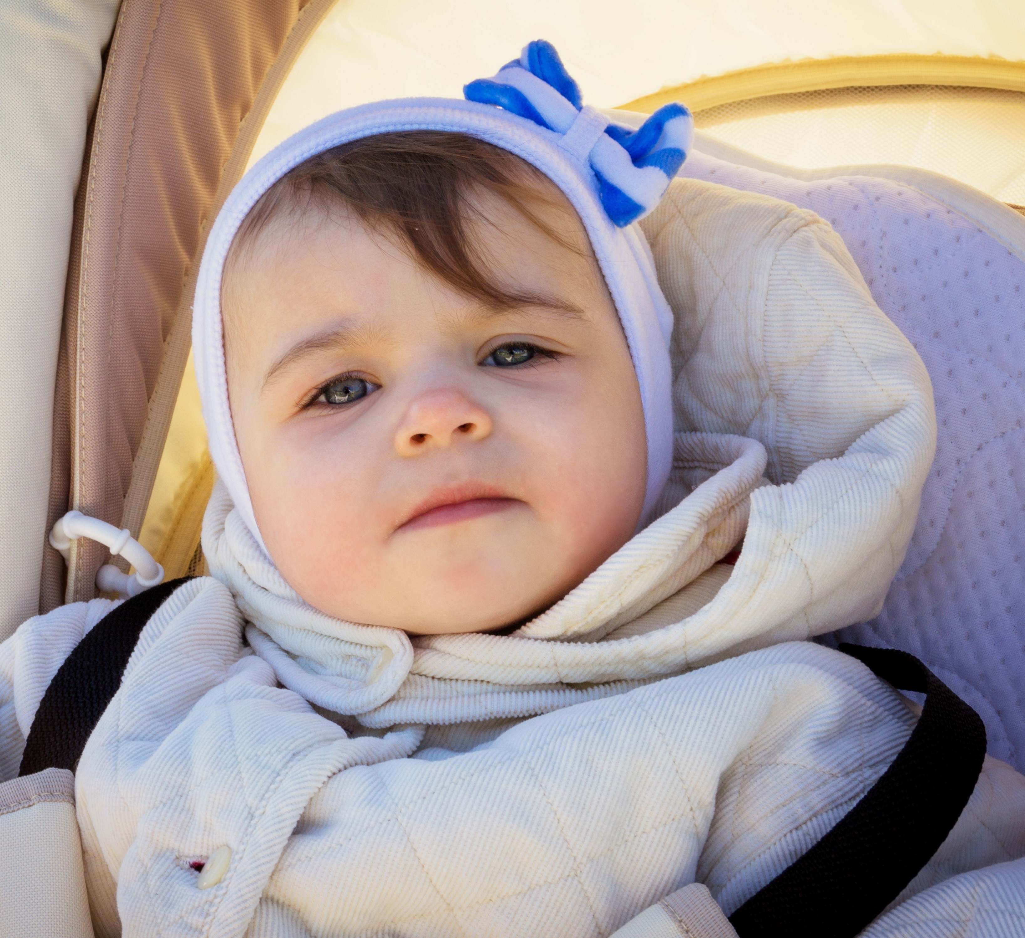 Little girl wearing a hat in pram 