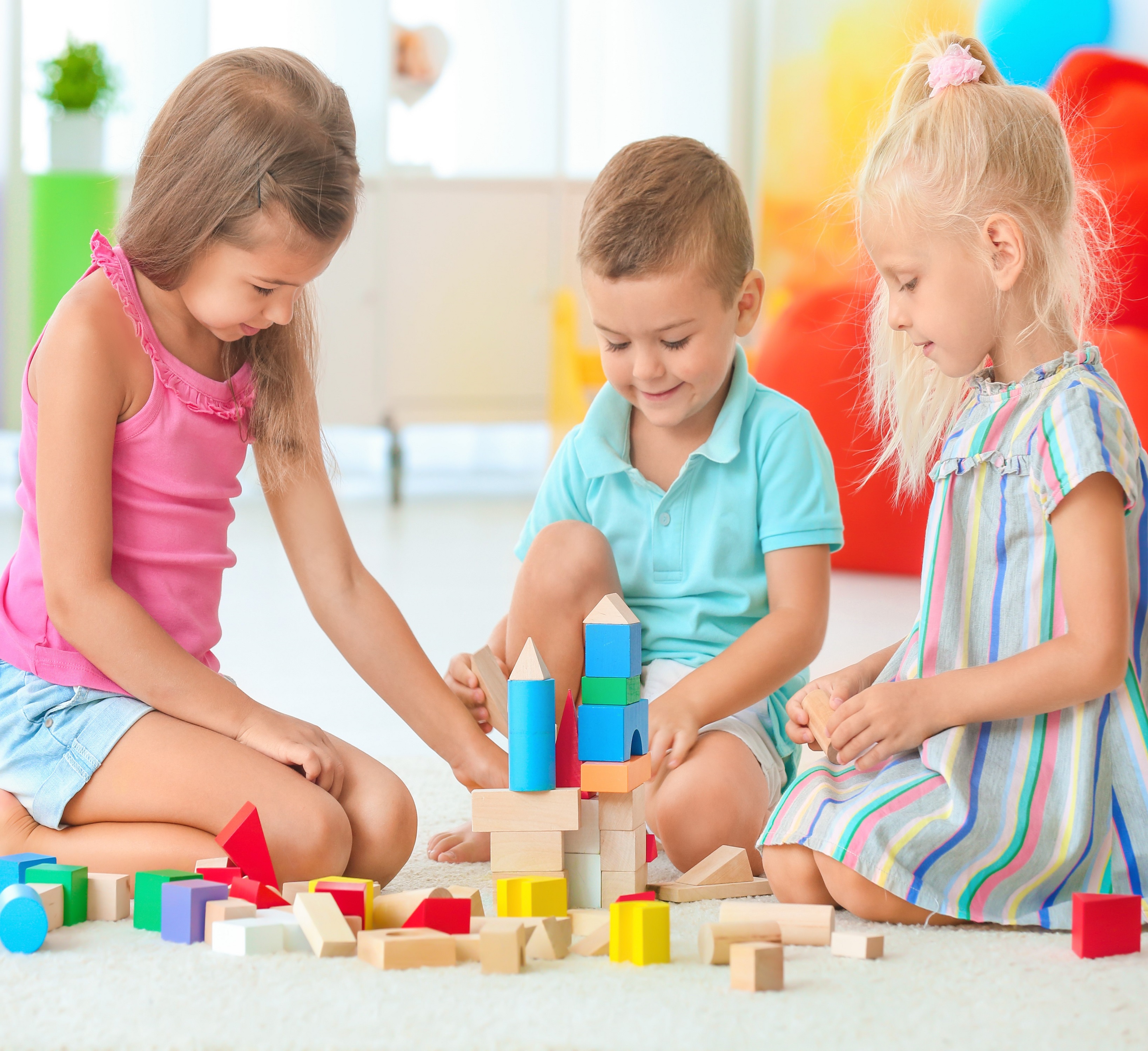 Sisters and brother playing blocks together