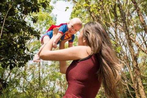 image to highlight Adoption Now single adoption blog - woman holding baby up in the air