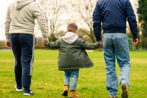 Male same sex adopters walking in park