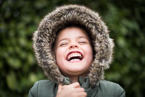boy in hood laughing at camera