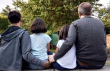 family sitting on a bench.